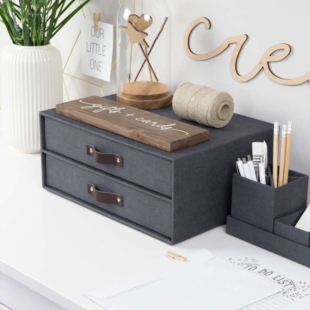 Schubladenbox auf Tisch, enthält Seilrolle, Schild „gifts + cards“ und Vase.