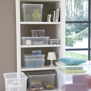 Weiße Regale mit Klarsichtboxen voller Gegenstände, Garten im Hintergrund.