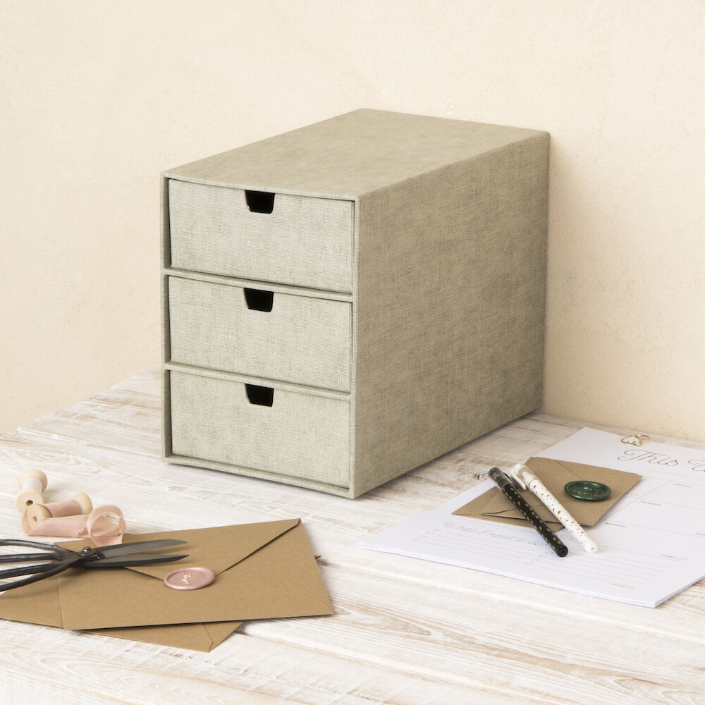Die INGRID Schubladenbox 3 Fächer - Linnen Canvas von Bigso steht auf einem hellen Holztisch und hilft bei der Büroorganisation mit braunen Briefumschlägen, Briefpapier, Stift, Wachsstift, Wachssiegelstempel und Schere.