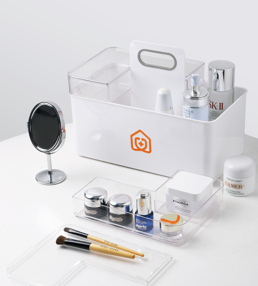 Der BNB x VCN Medikamenten Organizer Weiss bietet Platz für Hautpflegeprodukte, einen runden Spiegel, Pinsel und durchsichtige Schalen mit Cremes und Flaschen, alles übersichtlich auf einer weißen Fläche angeordnet.