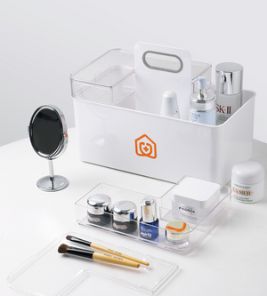 Der BNB x VCN Medikamenten Organizer Weiss bietet Platz für Hautpflegeprodukte, einen runden Spiegel, Pinsel und durchsichtige Schalen mit Cremes und Flaschen, alles übersichtlich auf einer weißen Fläche angeordnet.