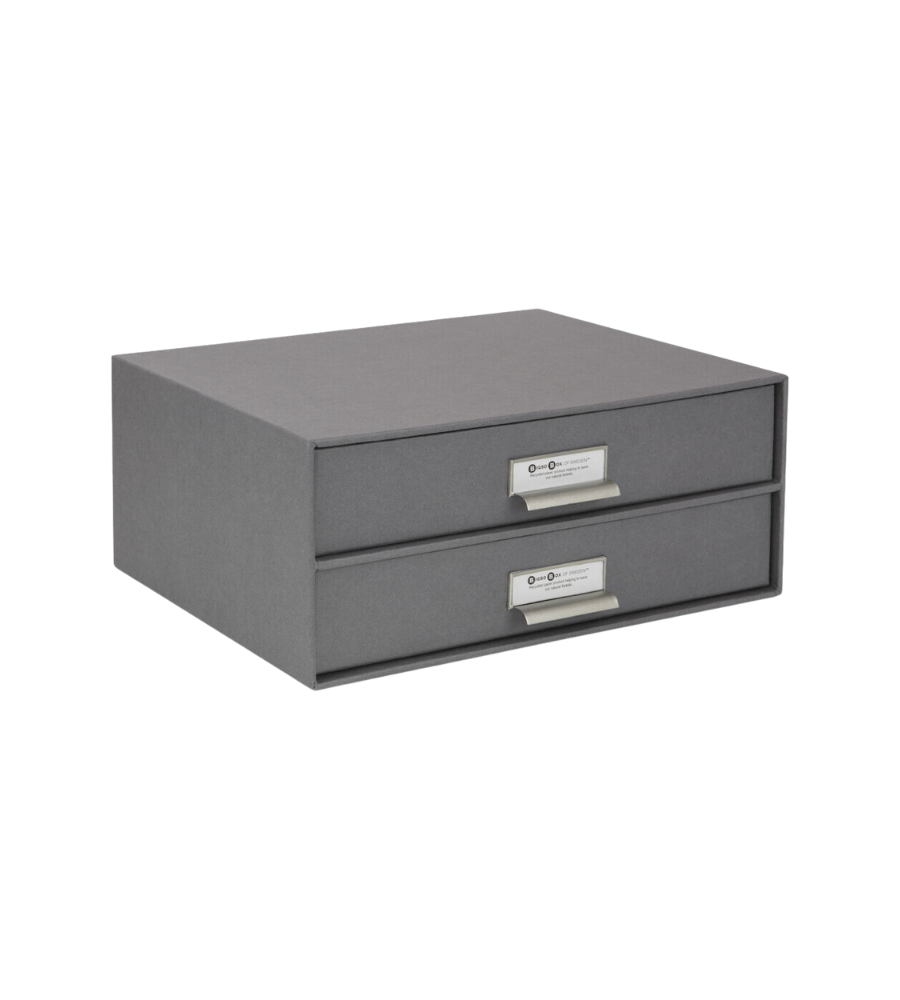 Graue Pappschubladenbox mit Metallschildern zur Organisation im Büro.