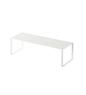 Weiße Metallbank minimalistisch stehend auf schwarzem Hintergrund.