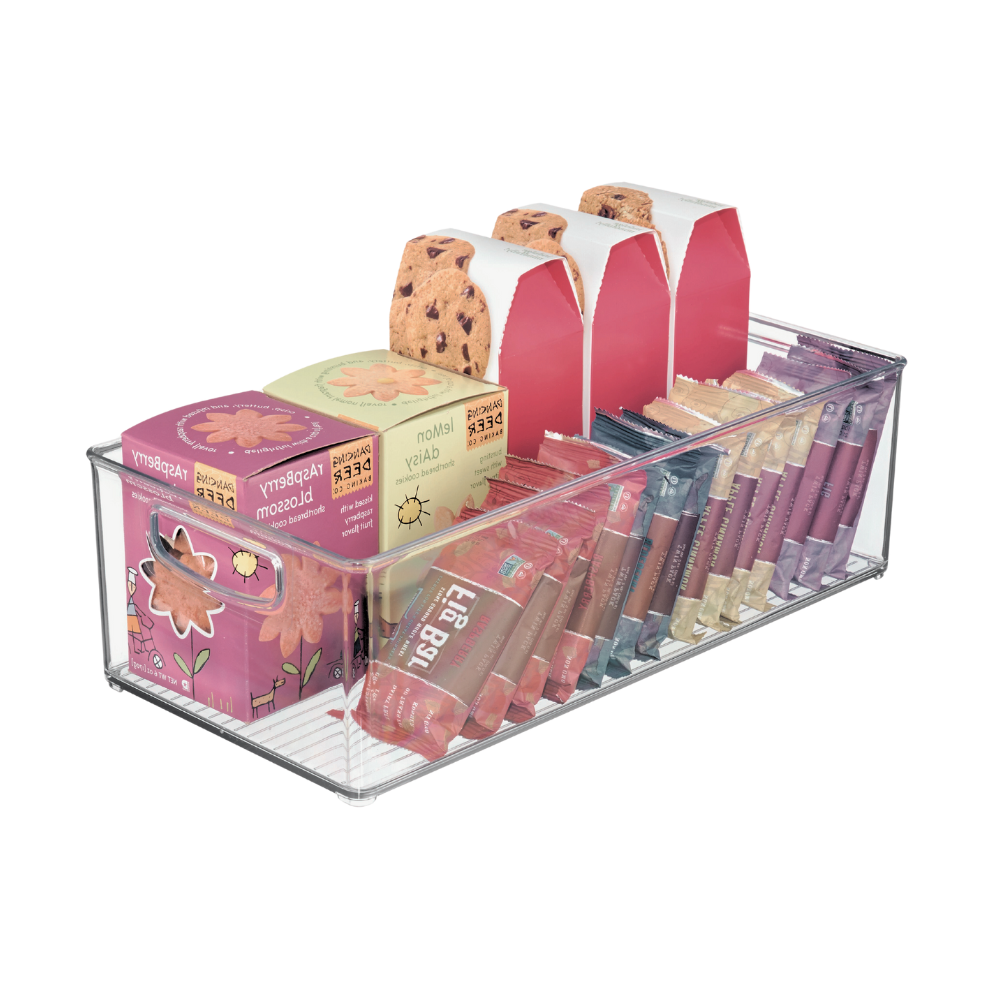 Im extralangen, durchsichtigen Aufbewahrungsbehälter von iDesign BINZ lassen sich Himbeerblütentee-Boxen, Schokoladenkekskartons, Honigstick-Päckchen und Lipgloss-Tuben ordentlich und in geordneten Reihen aufbewahren.