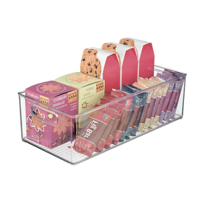 Im extralangen, durchsichtigen Aufbewahrungsbehälter von iDesign BINZ lassen sich Himbeerblütentee-Boxen, Schokoladenkekskartons, Honigstick-Päckchen und Lipgloss-Tuben ordentlich und in geordneten Reihen aufbewahren.