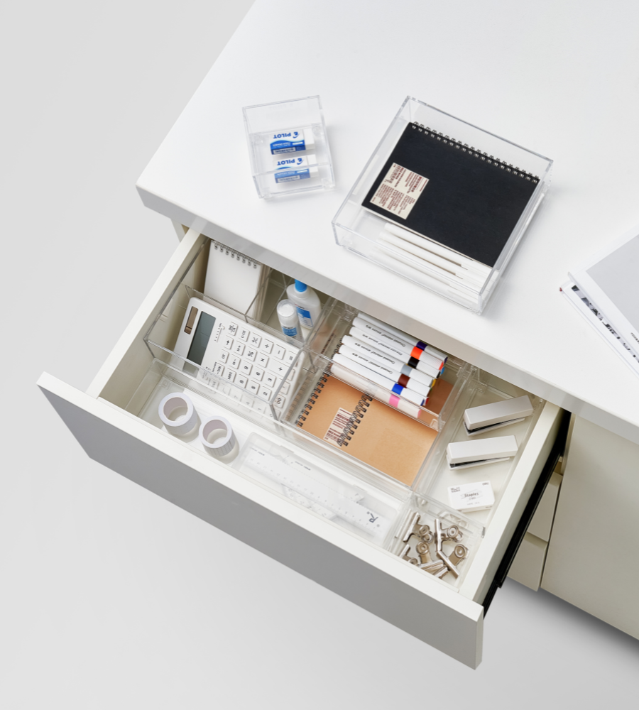 Un tiroir de bureau ouvert accueille l'organiseur de tiroir BNB x VCN SLIDE KLAR - différentes tailles, qui permet de ranger soigneusement stylos, surligneurs, calculatrice, ruban adhésif, gommes, cahier et trombones ; un cahier fermé et des gommes sont posés dessus. Parfait pour organiser les tiroirs.