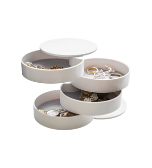 Türmeckiges Schmuckkästchen entfaltet Fächer mit Ringen, Uhren und Armbändern in neutraler Umgebung.