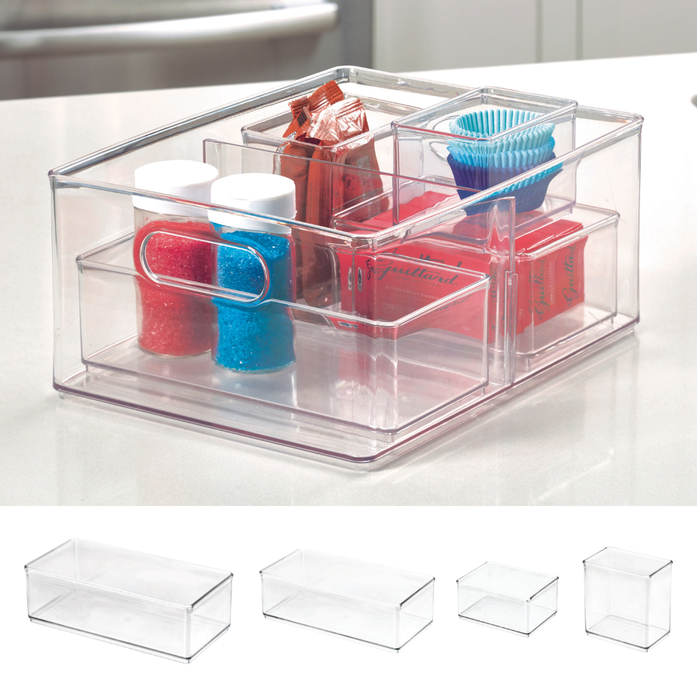 Transparent storage box with spice shakers, coffee packets, and chocolate wrappers on the kitchen counter.