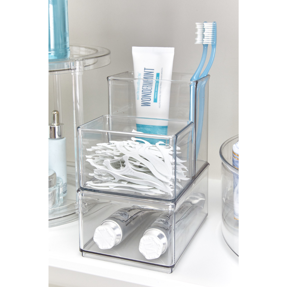 Storage system with toothpaste, toothbrushes, and dental floss in the bathroom, tube of "WONDERMINT" visible.